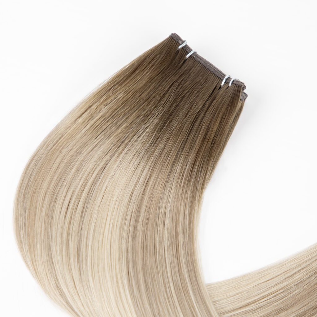 Ombre hair extensions showcasing a seamless blend from dark roots to light blonde tips, emphasizing versatility for styling and color enhancement.
