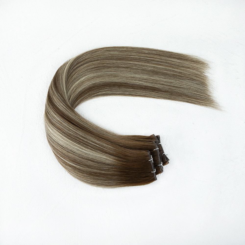 Brown and blonde clip-in hair extensions arranged elegantly on a white background, showcasing their texture and style for hair enhancement.