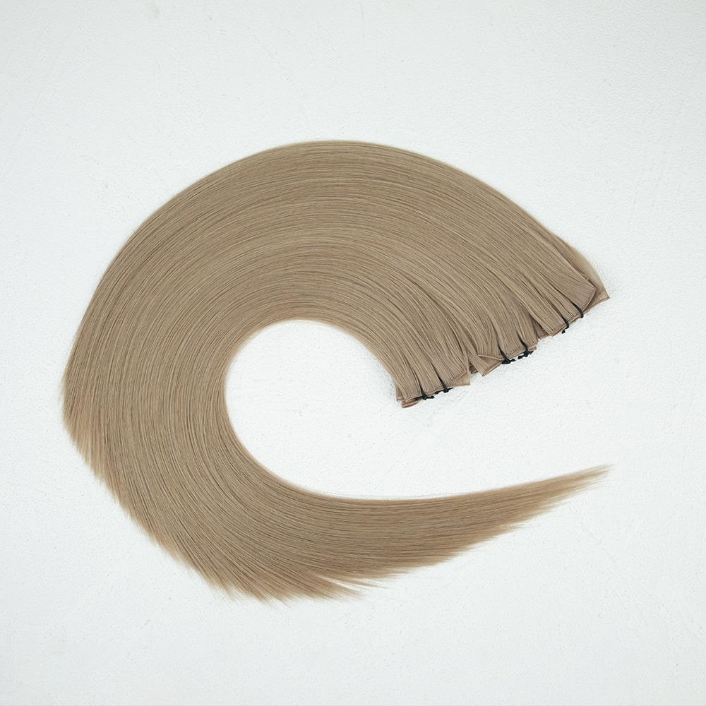 Long, straight, blonde hair extensions laid in a curved shape against a white background, showcasing their texture and style for beauty applications.